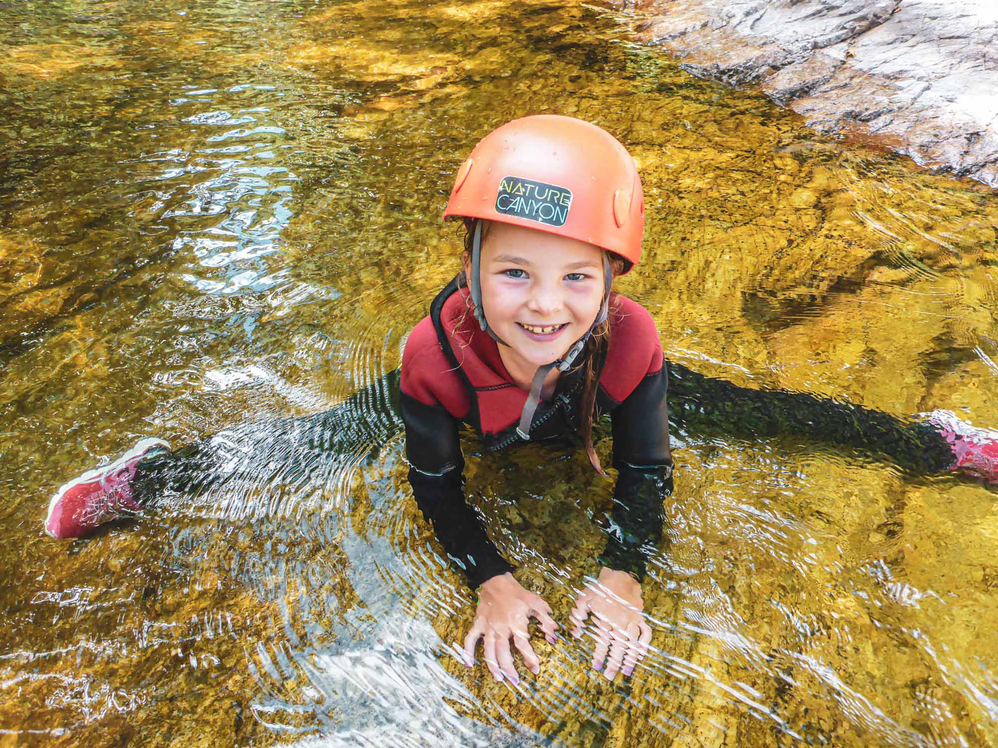 Jeune enfant dans la rivière sur le parcours famille demi-journée canyoning Azéro avec Nature Canyon Ardèche