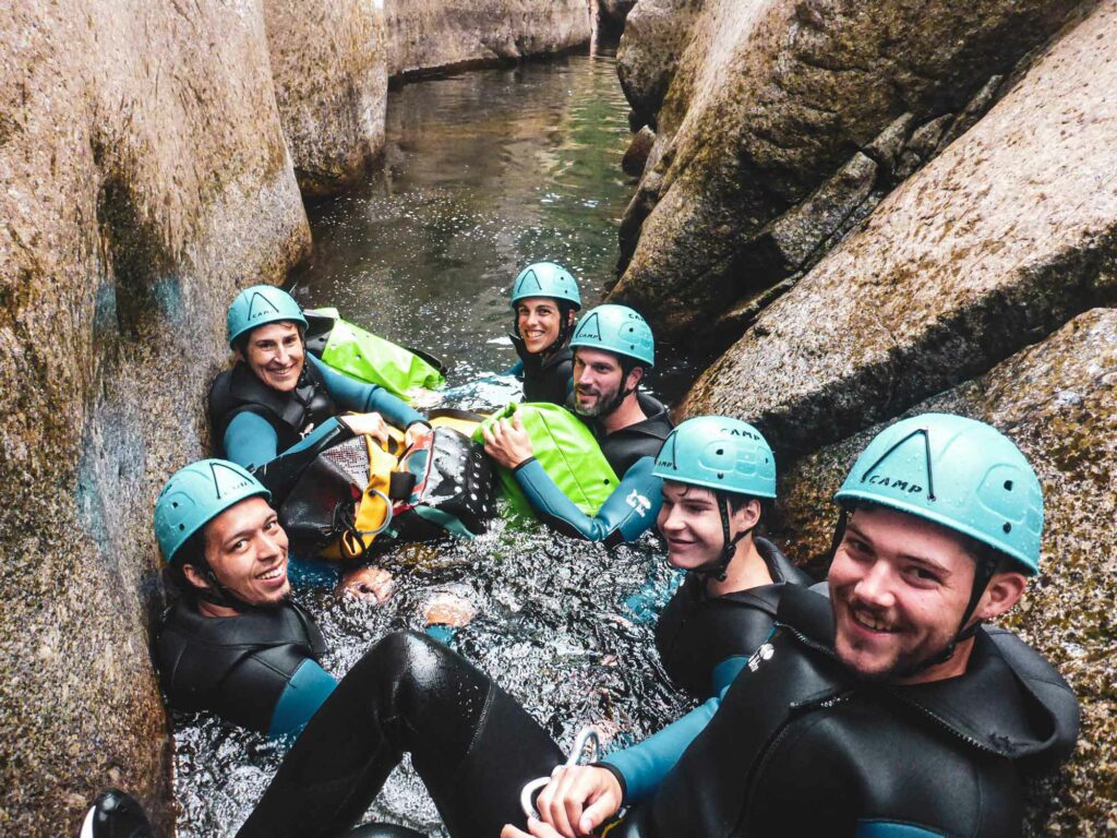 Groupe de personne dans une étroiture dans la rivière du Chassezac lors d'une sortie canyoning avec Nature Canyon Ardèche