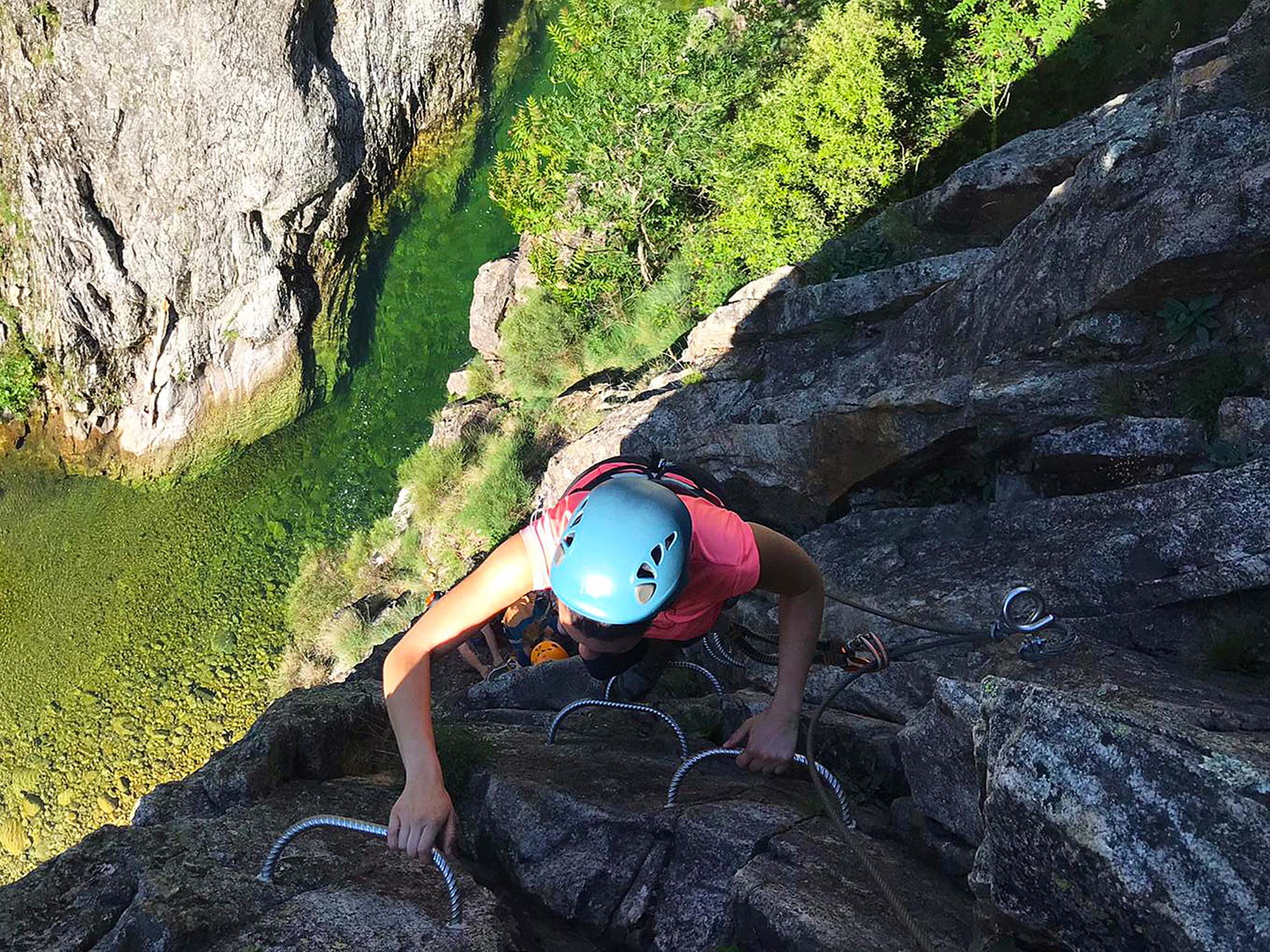 Groupe pratiquant l'activité Via-Ferrata, au-dessus du Pont du Diable à Thueyts en Ardèche avec un guide de Nature Canyon.